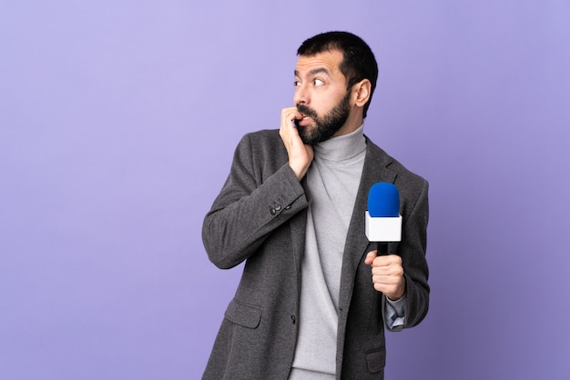 Young journalist man over isolated wall