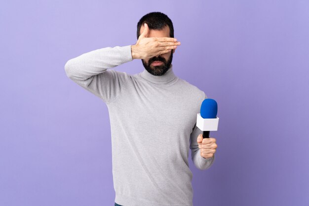 Young journalist man over isolated wall