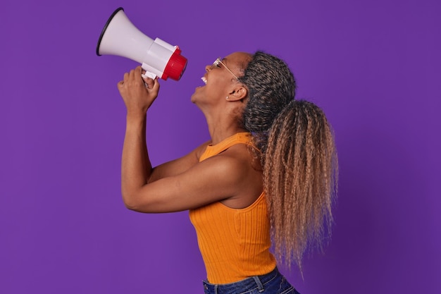 Photo young joy inspired african american woman using megaphone stands in studio