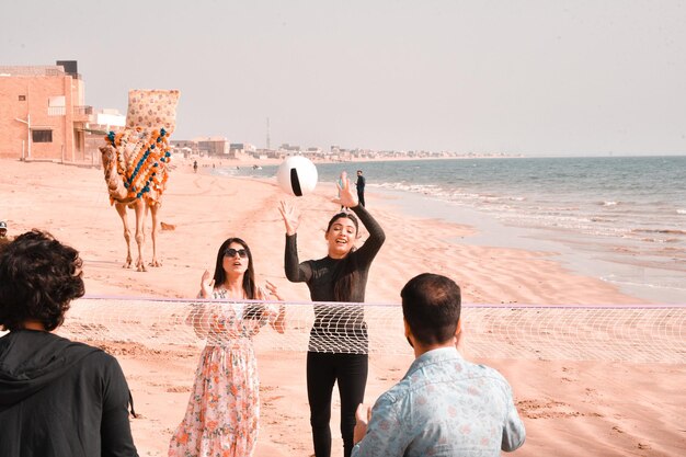 young joyful happy couples playing football on beach indian pakistani model