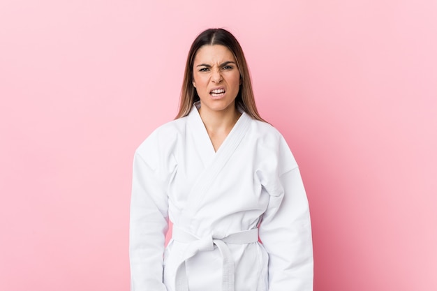 Young karate woman screaming very angry and aggressive.