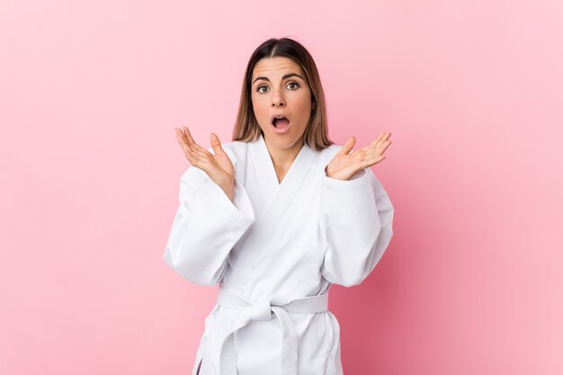 Young karate woman surprised and shocked.