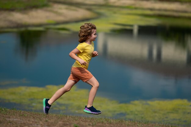 Photo young kid running and smiling in the park active little kid running along street during leisure spor