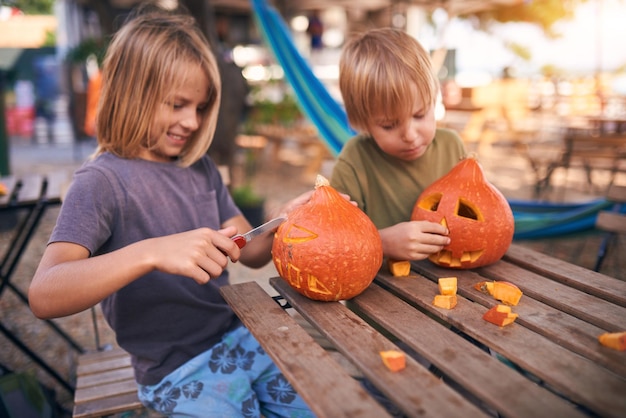 ハロウィーンのカボチャを彫る若い子供たち