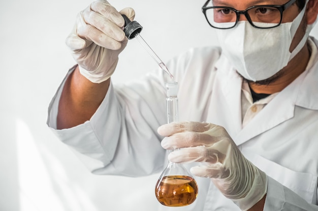 Foto il giovane assistente di laboratorio prepara lo strumento per l'esperimento di laboratorio chimico in laboratorio