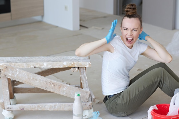 Young lady between 30 and 40 years old is renovating apartment.