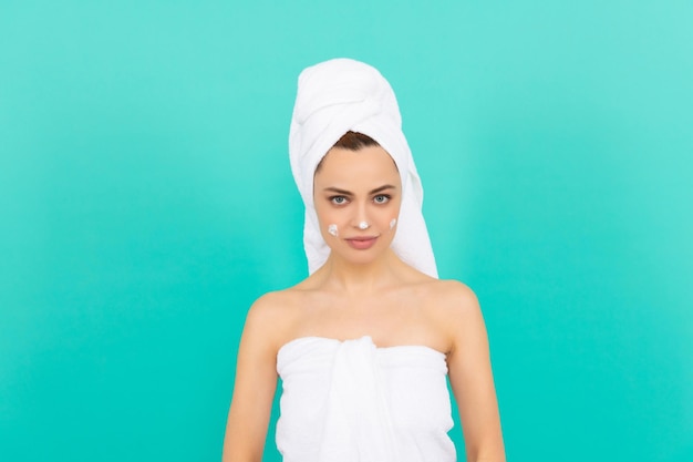 Young lady applying cream on blue background