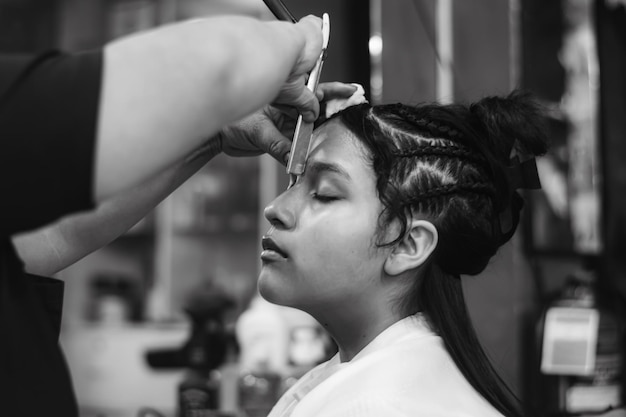 Young lady applying makeup in a spa or hair salon, black and white color photo.