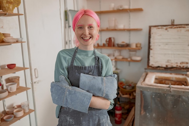 Young lady artisan ready for work in ceramic workshop