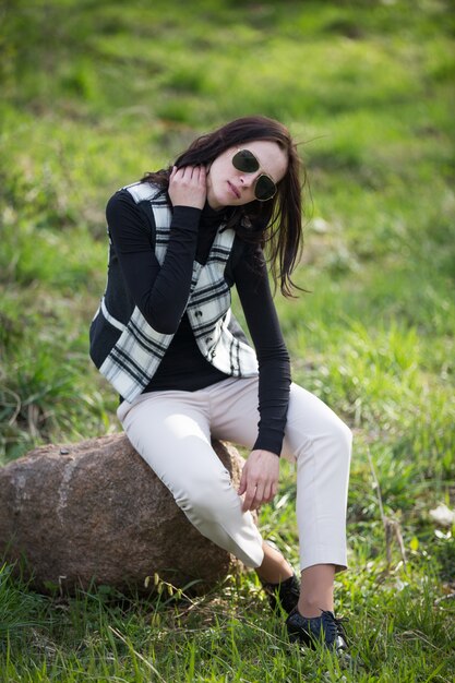 Foto giovane donna in giacca cellulare e occhiali da sole neri