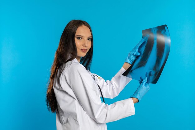 A young lady doctor is holding an xray of her lungs and is checking for ammonals