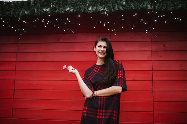 young lady in dress standing near decorated house for Christmas