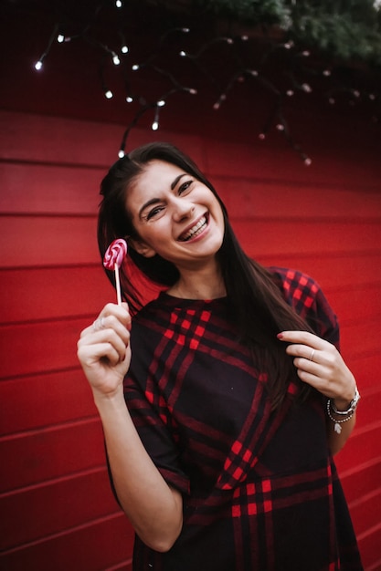 young lady in dress standing near decorated house for Christmas