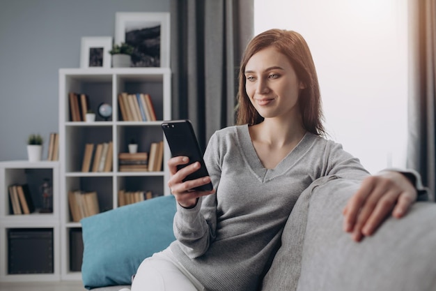 Young lady enjoying leisure time with smartphone