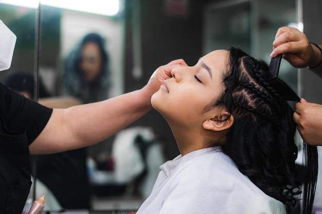 Young lady getting makeup and hair done in a professional spa or hair salon.