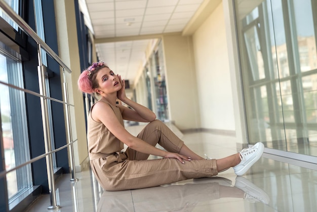 Young lady inside long corridor posing in pink glamour dress