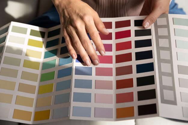 young lady interior graphic designer illustrator think on project hold palette of various colored samples in hands woman client customer choose example of colors before apartment remodeling close up