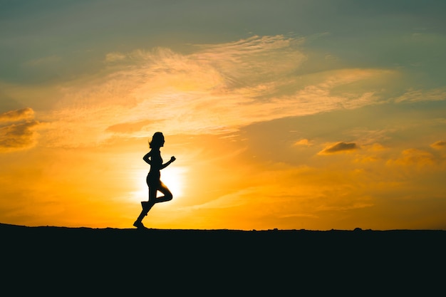 Young lady running on a rural road during sunset