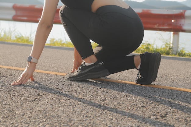 日没時に田舎道を走る若い女性