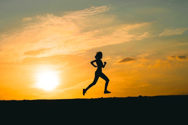 Young lady running on a rural road during sunset