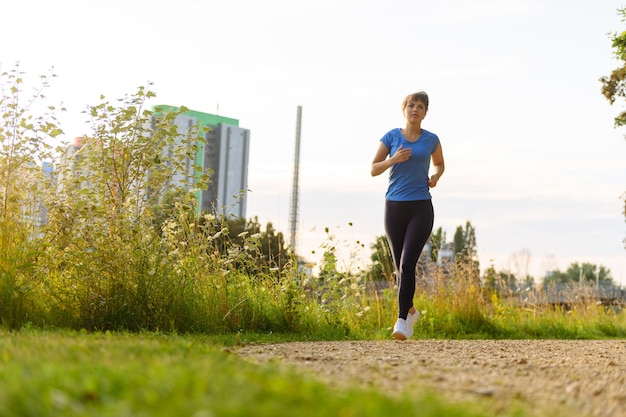 Young lady running on a rural road during sunset