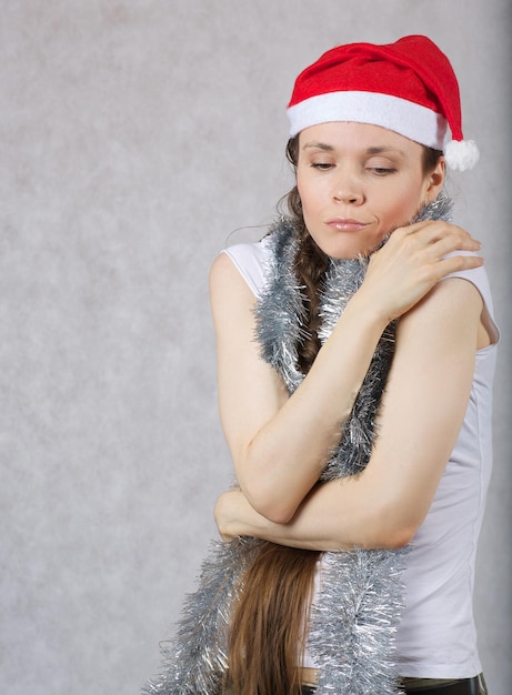 Foto giovane signora con un cappello da babbo natale, spazio libero per un messaggio.