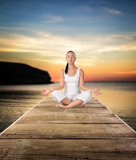 Young lady sitting in lotus position on beach