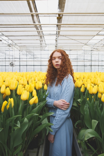 Young lady standing between flowers