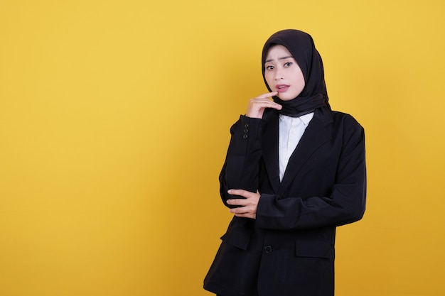 Young lady standing in thinking pose in black suit and looking