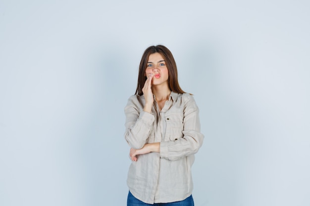 Giovane donna che soffre di mal di denti in abbigliamento casual, jeans e sembra indisposta. vista frontale.