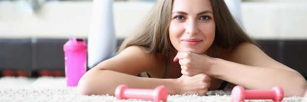 Young lady take break after physical workout and laying on carpet