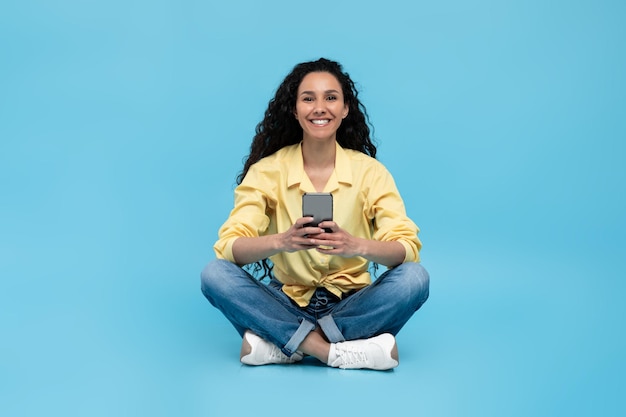 스마트폰을 사용하여 인터넷을 서핑하는 친구와 비디오 블루를 보면서 온라인 채팅을 하는 젊은 여성