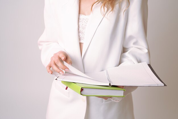 Young lady in white suit turns the page in her notebook