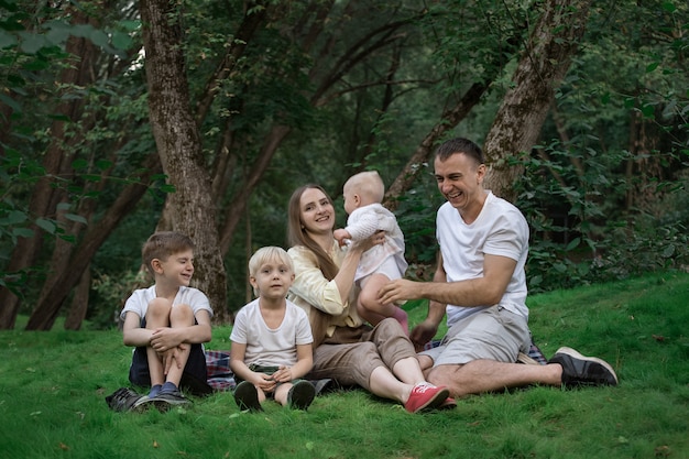 Young large family have a picnic outdoor. Mother father and three children. Happy family