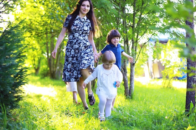 Young large family on a summer morning walk Beautiful mother with children is playing in the park