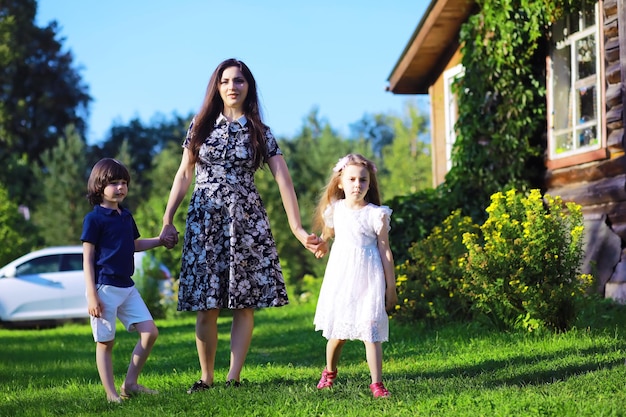 Young large family on a summer morning walk Beautiful mother with children is playing in the park