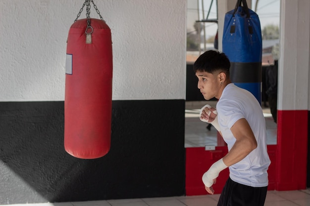 Wall Mural Latin Boxers doing some training on a punching bag at a