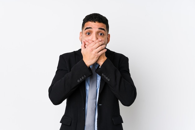 Young latin business woman against a white isolated shocked covering mouth with hands.