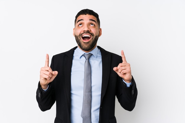 Young latin business woman against a white wall isolated pointing upside with opened mouth.