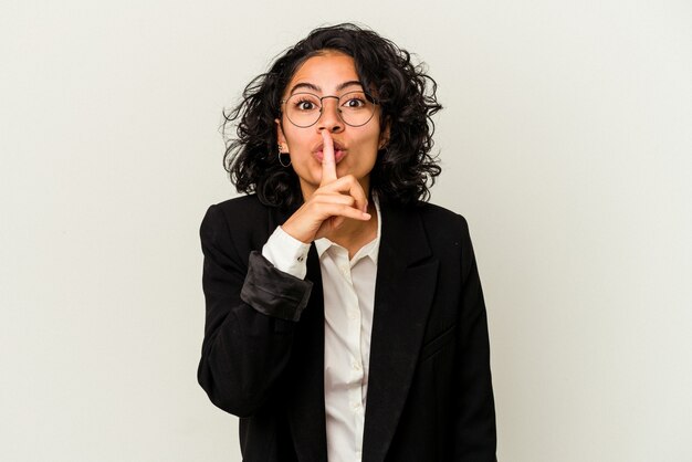 Young latin business woman isolated on white background keeping a secret or asking for silence.