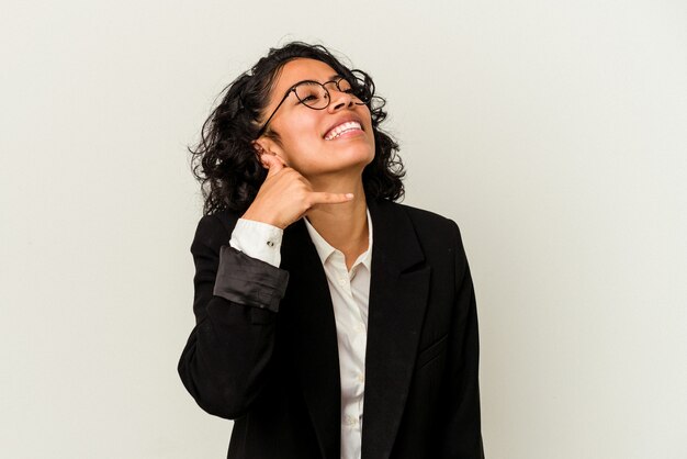 Young latin business woman isolated on white background showing a mobile phone call gesture with fingers.