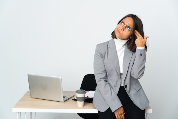 Young latin business woman working in a office isolated on white background with problems making suicide gesture