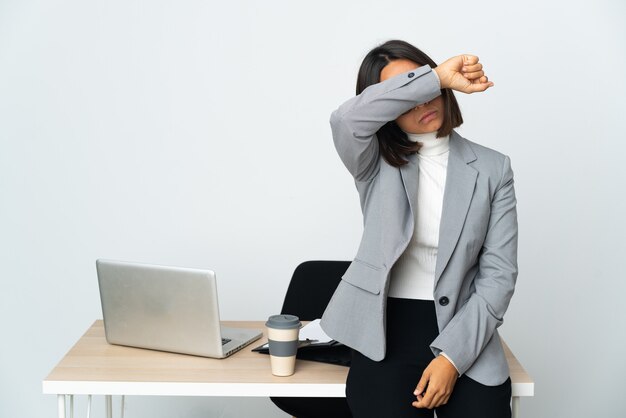 Young latin business woman working in a office isolated on white background