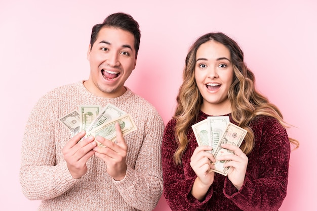 Young latin couple holding dollars