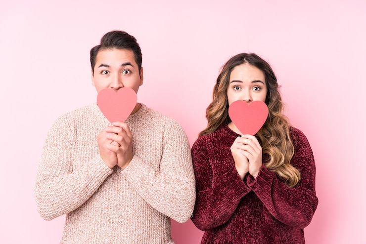 Photo young latin couple holding a heart sticker