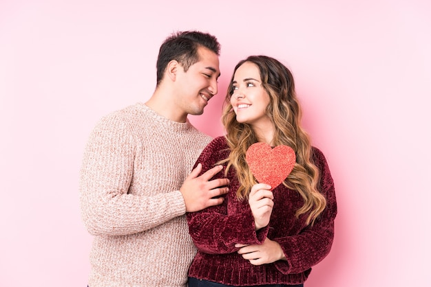 Young latin couple holding a heart sticker