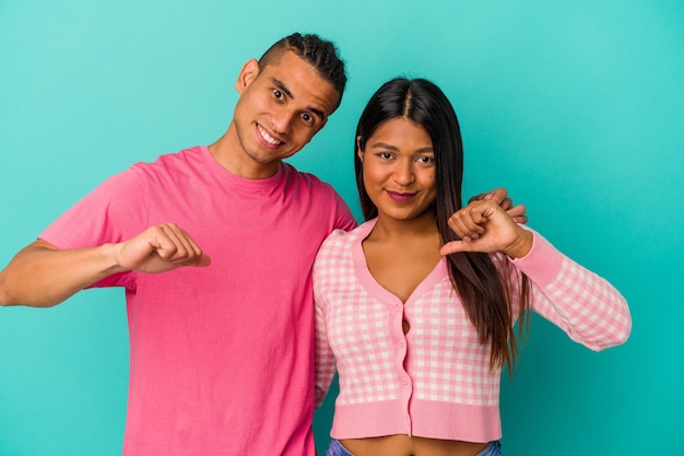 Young latin couple isolated on blue background feels proud and self confident, example to follow