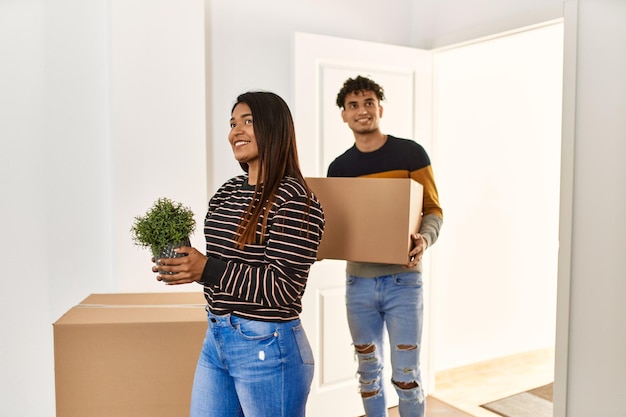Young latin couple smiling happy getting in at new home.