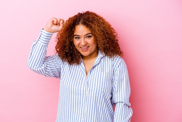 Young latin curvy woman isolated on pink wall celebrating a victory, passion and enthusiasm, happy expression