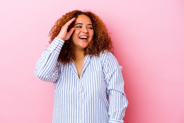 Young latin curvy woman isolated on pink wall joyful laughing a lot